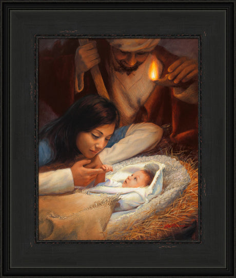 Mary holding baby Jesus' hand with Joseph watching over the manger scene