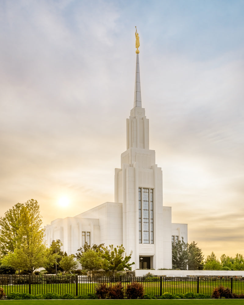 The Twin Falls Idaho Temple with a bright sunburst in the sky.