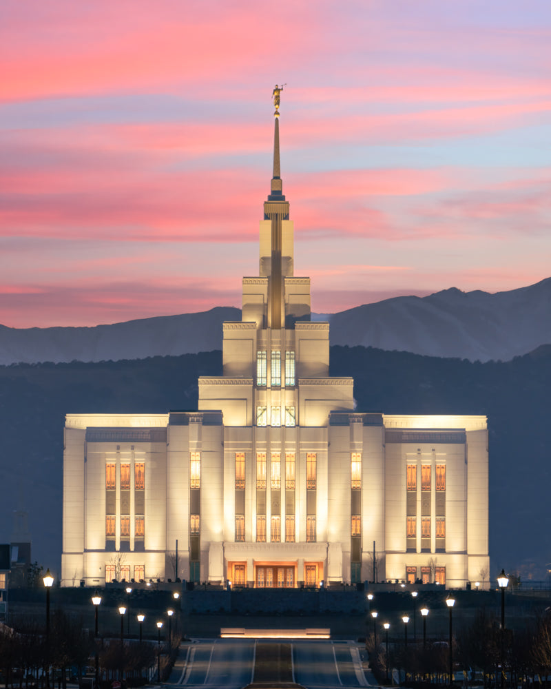 The Saratoga Springs Utah temple in the evening with pink clouds and mountains.