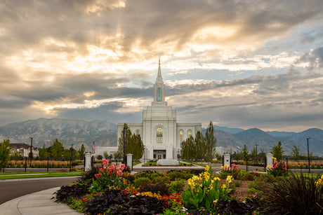 The Orem Utah Temple with light shining through the clouds.