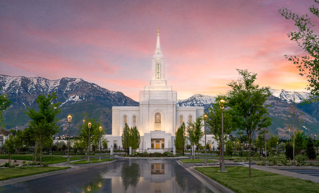 The Orem Utah Temple with mountains and a sunset sky.