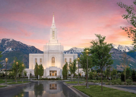 The Orem Utah Temple with mountains and a sunset sky.