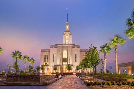 The Red Cliffs Utah Temple in the evening with palm trees.