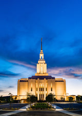 The Red Cliffs Utah Temple lit up in the evening.