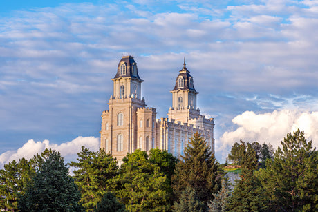 Manti Temple standing above the forest trees.