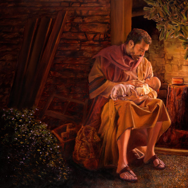 Joseph holding infant Jesus outside of the stable.