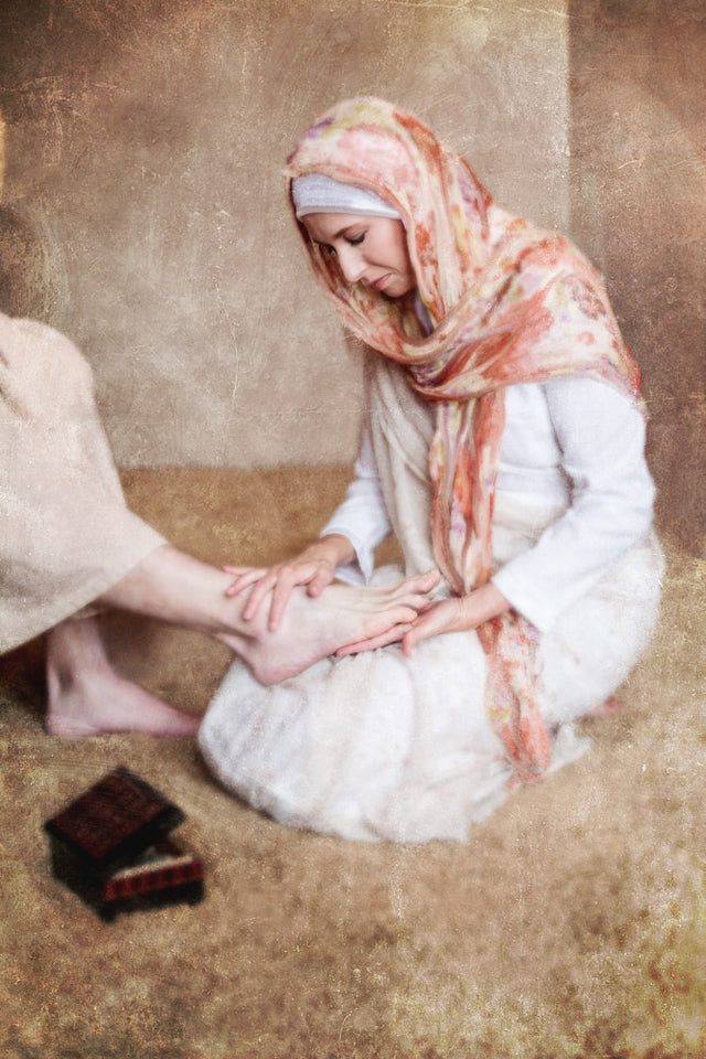 Mary holding Jesus's foot in her hands attoning. 