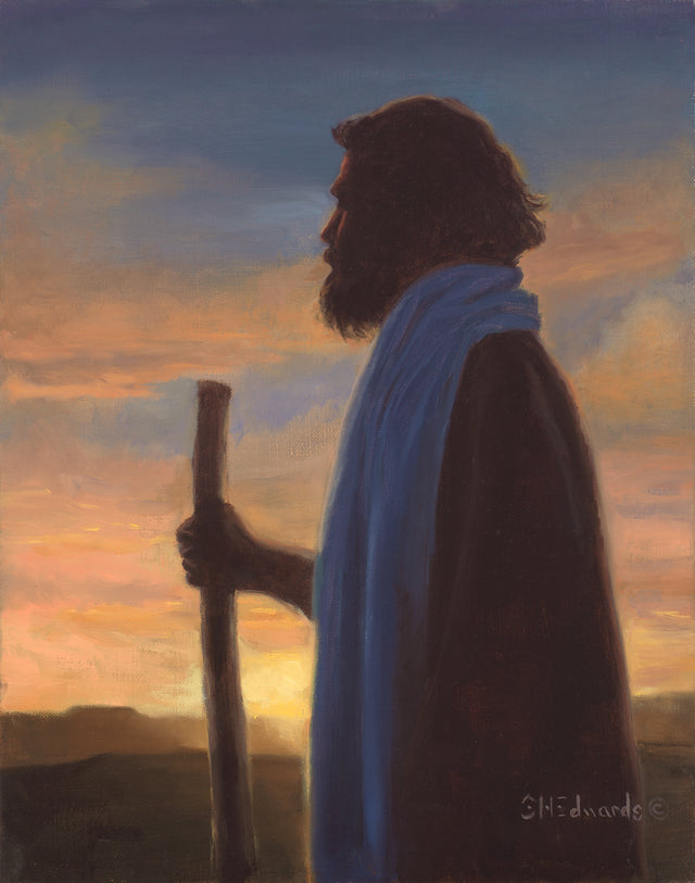 Jesus Christ as the good shepherd standing with a staff at sunset. 